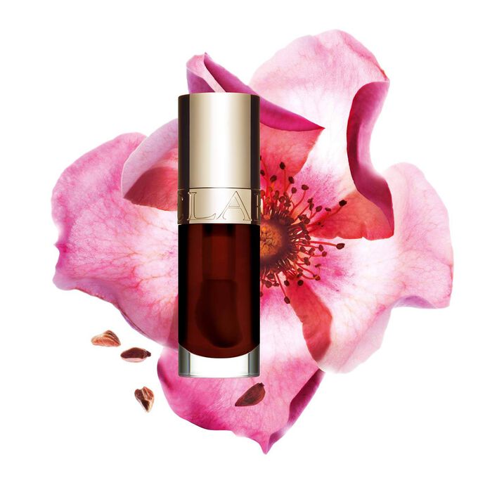 Packshot of Clarins Lip Comfort Oil Chocolate, placed next to a sweetbriar rose on a light pink background.
