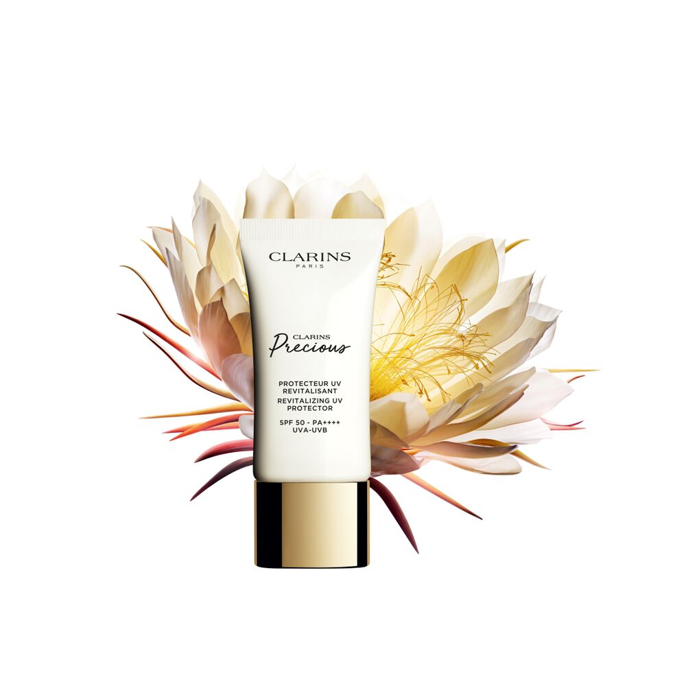Packshot of the anti-aging UV Protection tube displayed next to a shiny moonlight flower