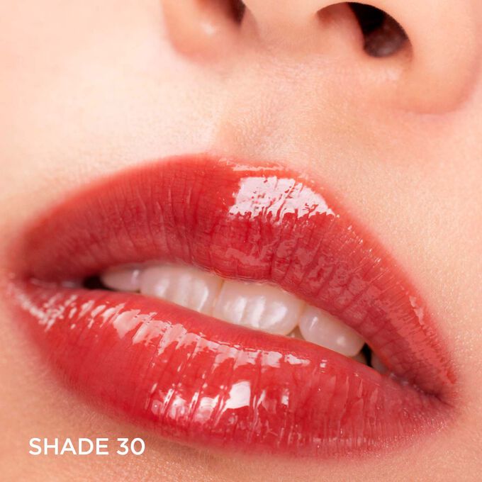 Close-up of lips wearing Clarins Lip Comfort Oil - Limited Edition in Brick shade, offering hydration, plumping, and gloss.