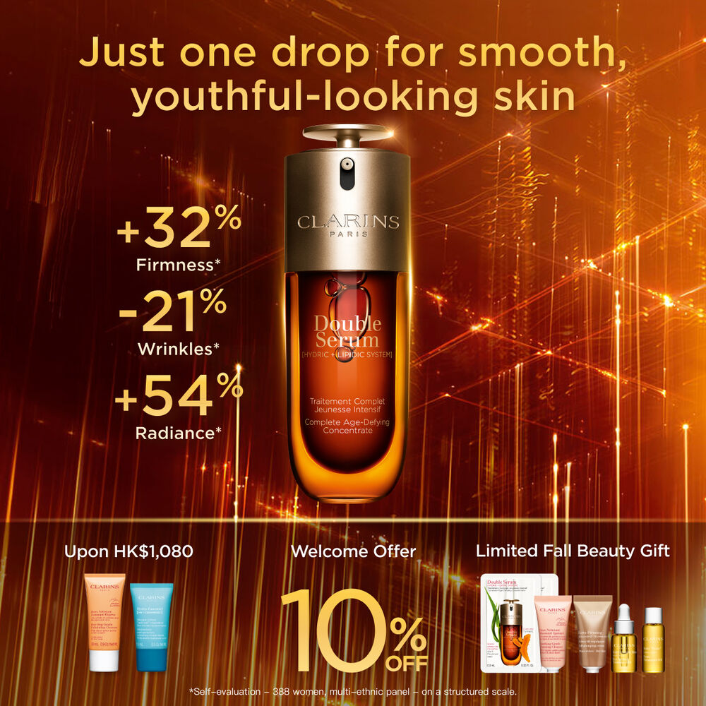 Packshot of the Clarins Double Serum displayed in front of its ingredient, including curcuma, on a gold background