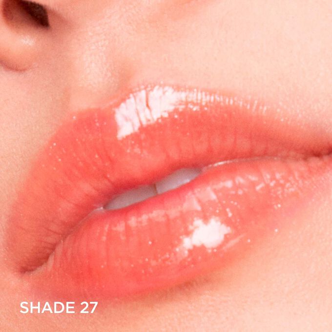 Close-up of lips wearing Clarins Lip Comfort Oil - Limited Edition in Peachy shimmery shade, hydrating, plumping, and glossy.
