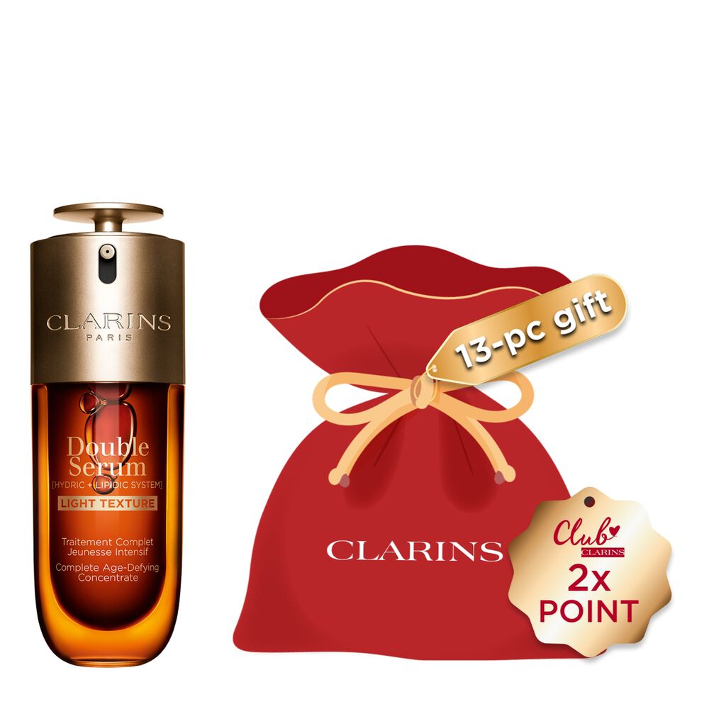 A 70ml bottle of Clarins Double Serum Light Texture among turmeric and proven&ccedil;al reed leaves against an orange background.
