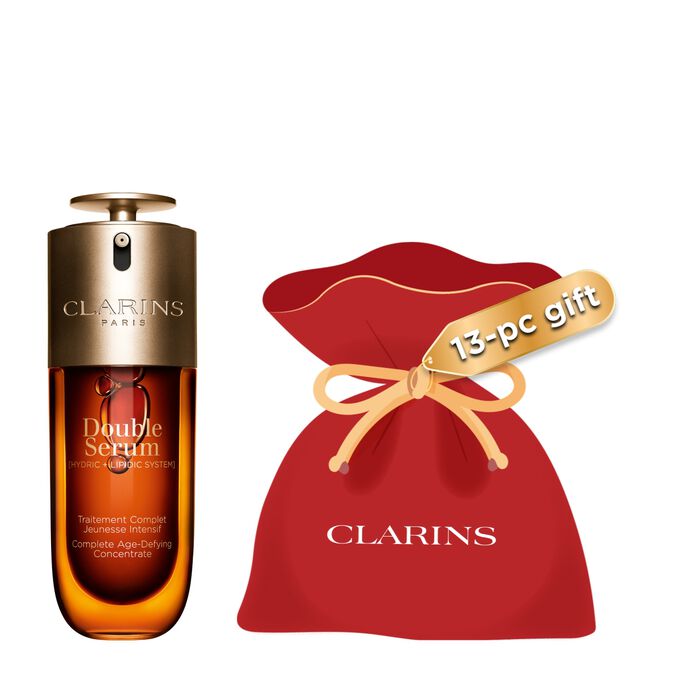 Packshot of the Clarins Double Serum displayed in front of its ingredient, including curcuma, on a gold background