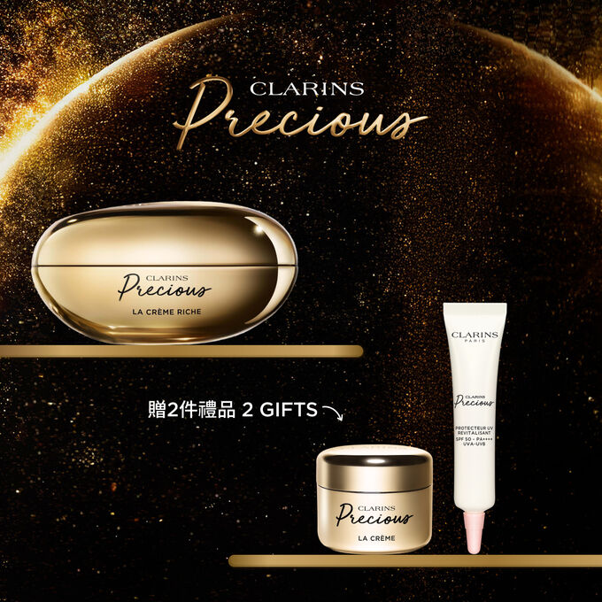 深色背景中的Clarins Precious至臻凝時面霜（滋潤型）的宣傳照，旁邊有一朵月神花。
